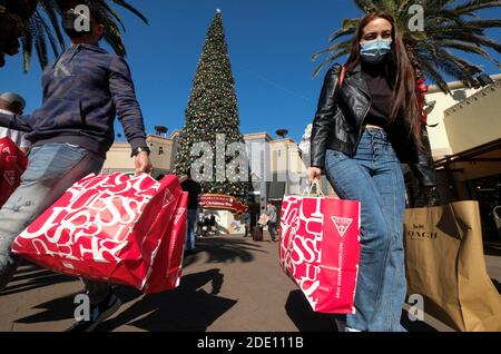 Los Angeles, California, Stati Uniti. 27 Nov 2020. Gli acquirenti che indossano maschere facciali portano borse per la spesa presso gli outlet Citadel il Black Friday durante la pandemia del coronavirus nel commercio, California, venerdì 27 novembre 2020. Credit: Ringo Chiu/ZUMA Wire/Alamy Live News Foto Stock