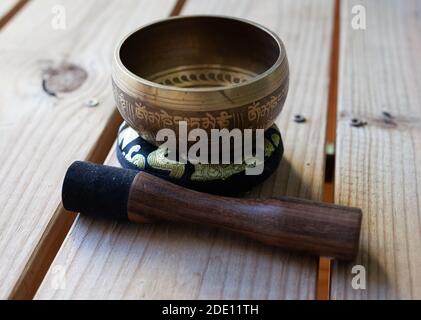 Coppa in bronzo con cuscino ornato su superficie boscosa Foto Stock