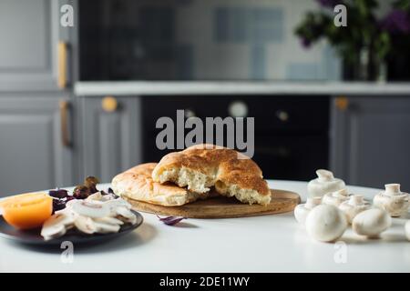 Il pane rotto è sul tavolo. Le verdure tagliate sono sul tavolo dell'insalata Foto Stock