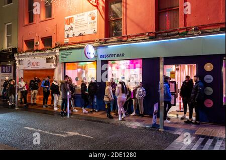 Cork, Irlanda. 27 Nov 2020. La maggior parte del centro di Cork è stata tranquilla questa sera a causa di una grande presenza sul Garda dopo i problemi dello scorso fine settimana. Il Dessert Bar su Oliver Plunkett Street aveva grandi code. Credit: AG News/Alamy Live News Foto Stock