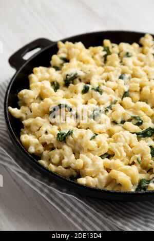 Spinach Mac e formaggio fatti in casa in una padella di ghisa, vista laterale. Primo piano. Foto Stock