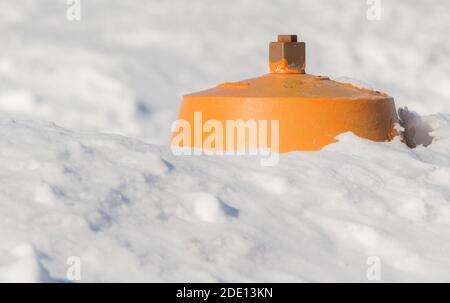 Un idrante antincendio quasi completamente sepolto in una riva di neve. La parte superiore è gialla, il resto non è visibile. Il primo piano e lo sfondo è neve. Foto Stock