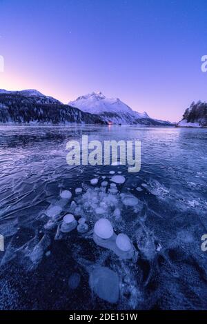 Bolle di ghiaccio intrappolate nel lago Sils con Piz da la Margna in background all'alba, Engadina, Cantone di Graubunden, Svizzera, Europa Foto Stock