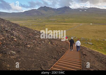 Esplorando un paesaggio vulcanico su un sentiero fino al cono e al cratere di Cenere Saxholl, al Parco Nazionale di Snaefellsjokull, all'Islanda occidentale, alle regioni polari Foto Stock