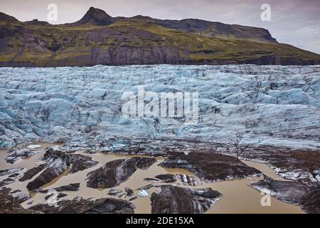 Sciogliendo il ghiaccio ai piedi di un ghiacciaio che si ritrae, Svinafellsjokull, Skaftafell National Park, Islanda meridionale, regioni polari Foto Stock