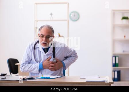 Medico maschile senior che lavora in clinica Foto Stock