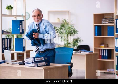 Anziano contabile di sesso maschile infelice con lavoro eccessivo sul posto di lavoro Foto Stock