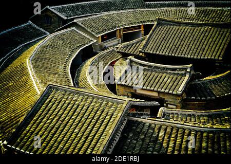 Tetti di tegole di Hakka tradizionali case di terracotta nella provincia del Fujian, vicino Tulou,Xibei (Cina). Classificato come mondo Patrimonio Unesco Foto Stock