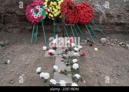 STEPANAKERT, NAGORNO KARABAKH - NOVEMBRE 05: I fiori adornano la tomba di un membro del servizio ucciso in combattimento durante un conflitto militare tra le forze armene e azerbaigiane in un cimitero militare in Stepanakert la capitale de facto dell'autoproclamata Repubblica di Artsakh o Nagorno-Karabakh il 05 novembre 2020. I combattimenti tra Armenia e Azerbaigian sul Nagorno-Karabakh, noto anche come Repubblica Artsakh, sono riesplose alla fine di settembre in una guerra di sei settimane con entrambi i paesi accusandosi reciprocamente di provocazioni che hanno lasciato migliaia di morti. Foto Stock