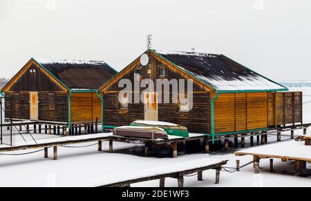 Tempo invernale sul lago di pesca. Villaggio galleggiante. Lago congelato, barca congelata, tempo congelato. Foto Stock