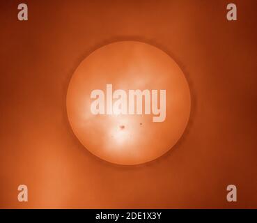 Londra, Regno Unito. 28 novembre 2020. Nuvole e nebbia creano un filtro attraverso il quale un enorme spot solare è visibile su un sole nuvoloso. Questo spot solare, AR2786, il più grande negli anni e molte volte il diametro del pianeta Terra è una fonte potenziale di riacutizzazioni solari di classe M. Il piatto più piccolo sulla destra è AR2785. Questa immagine è stata colorata. Credit: Malcolm Park/Alamy Live News. Foto Stock