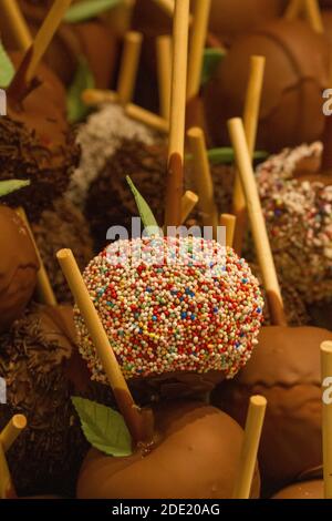 Mele ricoperte di cioccolato e centinaia e migliaia in vendita Ad un mercato di Natale Foto Stock
