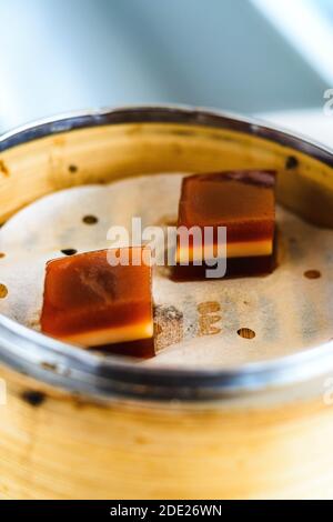 Un dessert di Jujube Jello dolce servito su carta in un cesto di bambù Foto Stock