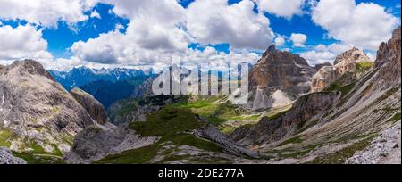 Intorno capanna e cima tre Cime, Dolomiti, Italia. Panorama con cime rocciose, prato verde e cielo blu nuvoloso. Foto Stock