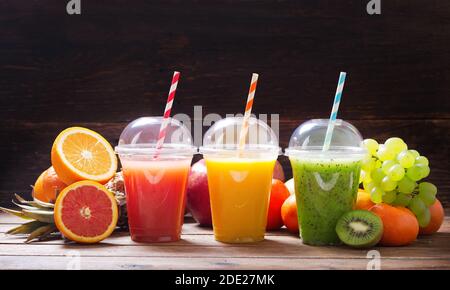bicchieri di succo di frutta e frullato con frutta fresca tavolo di legno Foto Stock