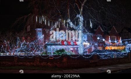 Una grande collezione di luci di Natale decorano la parte anteriore e il giardino di una casa nel nord-ovest dell'Inghilterra, Regno Unito. Foto Stock