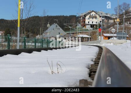 Binari ferroviari con neve.Schluchsee stazione ferroviaria in Germania sullo sfondo, nel paesaggio invernale Foto Stock