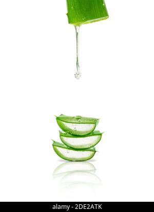 Gel di aloe vera che gocciola su foglie tagliate isolate su sfondo bianco. Foto Stock