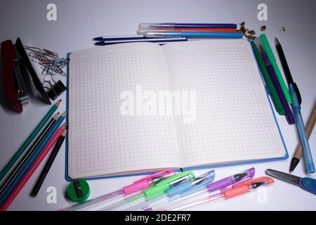 notebook e matite, penne in feltro e graffette. concetto di cancelleria. spazio di copia. isolato Foto Stock