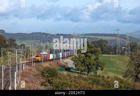 2 DB Cargo UK classe 90 locomotive elettriche su Linea principale della costa occidentale elettrificata a Cumbria con un container intermodale allenati Foto Stock