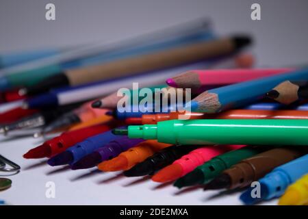 Un mucchio di cancelleria diversa. Pennarelli multicolore, graffette, spille, matite, penne. Foto di alta qualità Foto Stock