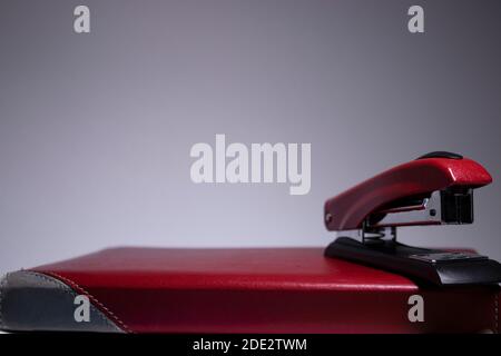 notebook rosso con cucitrice rossa. concetto di cancelleria. spazio di copia. isolato. Foto di alta qualità Foto Stock