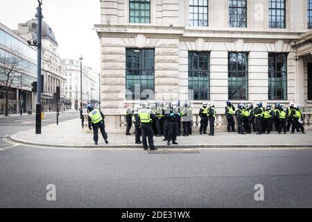 Londra, Regno Unito. 28 Nov 2020. La polizia INCONTRATA aspetta dietro l'angolo per una marcia di blocco per avvicinarsi da Piccadilly Circus. Il movimento Save Our Rights ha organizzato la manifestazione per unire le persone per la libertà, la giustizia e per sviluppare una vera democrazia che essi vedono minacciata a causa della legge Coronavirus. Credit: Andy Barton/Alamy Live News Foto Stock