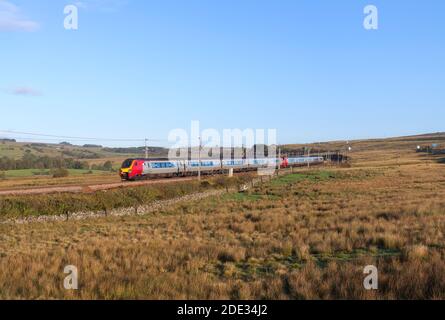 Avanti West Coast treni diesel Bomabrdier voyager in esecuzione sul Elettrificata linea principale della costa occidentale passando per la campagna Cumbria Foto Stock