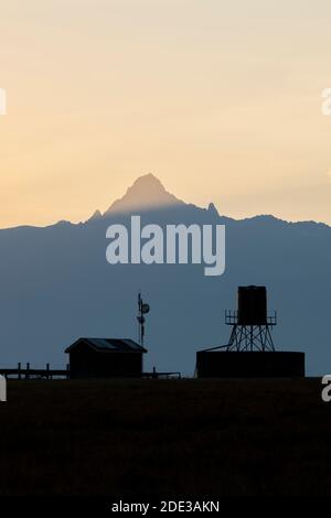 Africa, Kenya, Plateau di Laikipia, Conservatorio Ol Pejeta. Monte Kenya alba, montagna più alta in Kenya, 17,057 piedi UNESCO. Silhouette della stazione del bestiame. Foto Stock