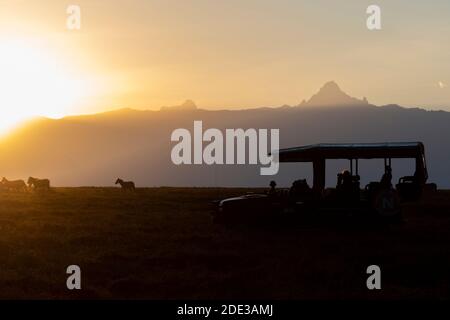 Africa, Kenya, Plateau di Laikipia, Distretto di frontiera settentrionale, Conservatorio di OL Pejeta. Monte Kenya alba. Safari in jeep con zebra in lontananza. Foto Stock