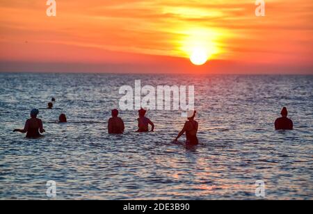 Brighton UK 28th November 2020 - UN gruppo di nuotatori di mare godersi il tramonto nel tardo pomeriggio sulla spiaggia di Brighton, mentre una bella giornata d'autunno calda si avvicina alla costa meridionale: Credit Simon Dack / Alamy Live News Foto Stock