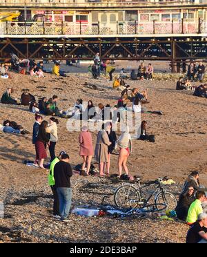 Brighton UK 28 Novembre 2020 - le folle godono del tramonto nel tardo pomeriggio e del soffio stellato sulla spiaggia e sul lungomare di Brighton, mentre una bella calda giornata d'autunno si avvicina alla chiusura sulla costa meridionale: Credit Simon Dack / Alamy Live News Foto Stock