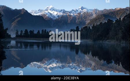 Il lago Matheson offre splendidi riflessi delle vette più alte della Nuova Zelanda: Aoraki (Mount Cook) e Mount Tasman. Foto Stock