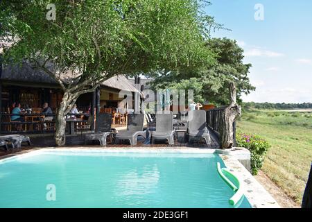 La piscina e l'area ristorazione coperta dell'Umkumbe Safari Lodge si affacciano sul fiume Sand nella Sabi Sand Game Reserve, Sudafrica. Foto Stock