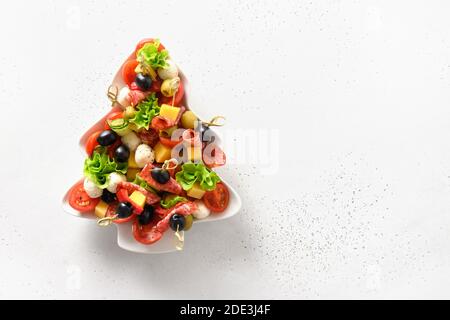 Spuntini di festa come canapes a forma di piatto di albero di Natale per festa di Natale isolato su bianco. Vista dall'alto. Spazio per il testo. Foto Stock