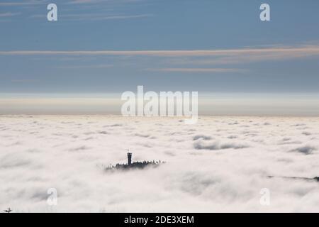 Schierke, Germania. 28 Nov 2020. Il Wurmberg con la sua torre di osservazione sorge fuori dal mare di nuvole. A causa del tempo di inversione, il sole splende sulle cime delle montagne, mentre le valli sono coperte da uno spesso strato di nuvole. Credit: Fahren/dpa-Zentralbild/ZB/dpa/Alamy Live News Foto Stock