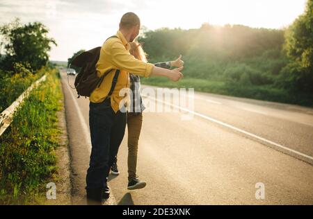 i turisti fermano le auto sulla strada, i giovani che viaggiano a piedi. strada estiva. Foto Stock