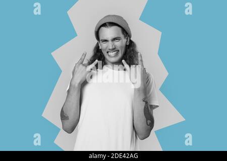 Giovane uomo hipster adulto che mostra rock n roll gesto Foto Stock