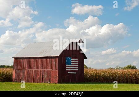 Un fienile di legno con un dipinto della bandiera Betsy Ross a 13 stelle (un primo disegno di bandiera americana) si trova vicino a campi di mais lungo la vecchia Route 66 a Nilwood, Illinois. Foto Stock