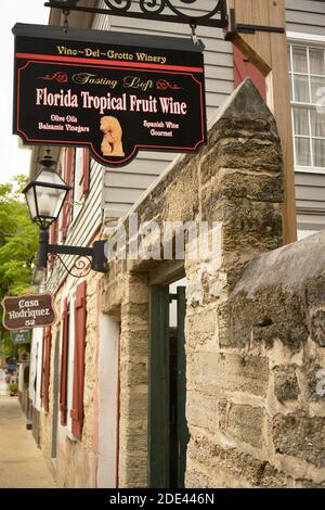 Cartello sopraelevato per la Florida Tropical Fruit Wine Shop lungo gli edifici realizzati in coquina nello storico quartiere coloniale di St. Augustine, Florida, USA Foto Stock