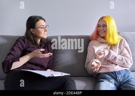 Ragazza teen che dà l'intervista al lavoratore sociale. Psicologo scolastico che parla con lo studente Foto Stock