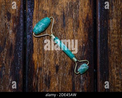 Piccolo rullo massaggiante blu, realizzato da Don Rocks, su legno marrone scuro Foto Stock