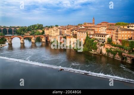 Il fiume Tarn che attraversa la città di Albi. Pont Vieux ponte e la Chiesa di Notre Dame du Breuil nel villaggio di Tarn, Occitanie Midi Pyrenees Francia. Foto Stock