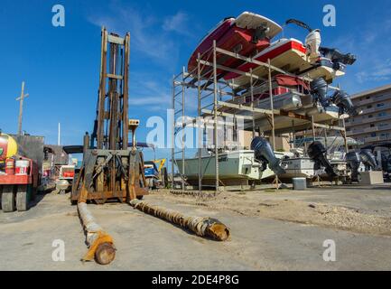 New Smyrna Beach, Stati Uniti. Un carrello elevatore della barca siede vicino alle barche in un arystack ad un marina della Florida. Foto Stock