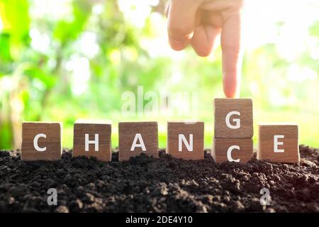 Possibilità di cambiamento, nuove opportunità, ottimismo e concetto di crescita della carriera. La mano maschile che cambia o che capovolgono la parola possibilità di cambiare i dadi dei blocchi di legno in natu Foto Stock