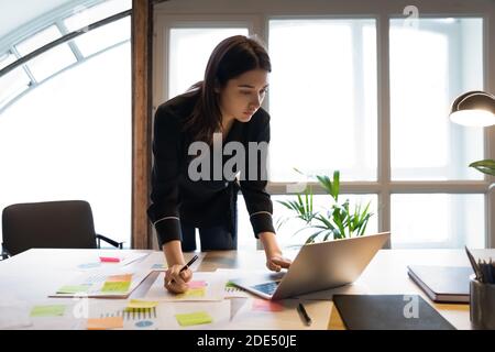 Fiducioso millennial indiano analista di affari femminile che prepara il rapporto statistico Foto Stock