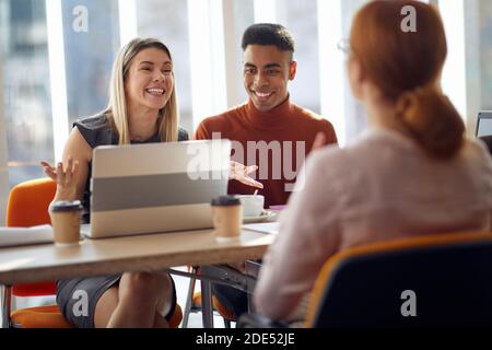 Commissione aziendale che gode di un'intervista in un'atmosfera piacevole con una donna che chiede un posto di lavoro. Persone, lavoro, azienda, business concept. Foto Stock