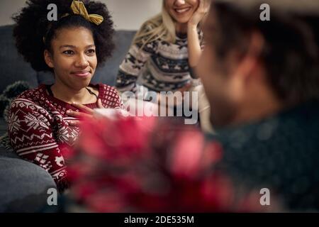grazie giovane afroamericana che riceve il regalo di natale da amici Foto Stock