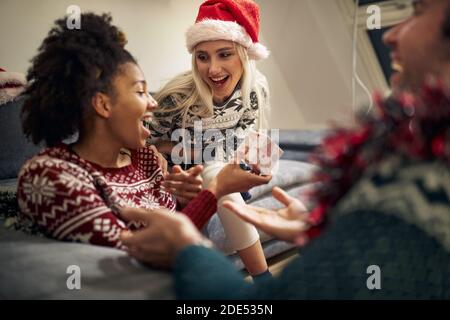 gruppo di giovani amici multietnici che ridono, si divertono, scambiano regali a natale Foto Stock