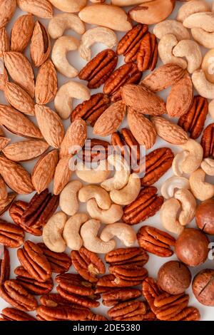 Composizione nutrizionale corretta di una foto verticale del modello di frutta a guscio assortita per striscioni, articoli o confezioni. Pecan, noci brasiliane, anacardi, mandorle e noci di macadamia Foto Stock